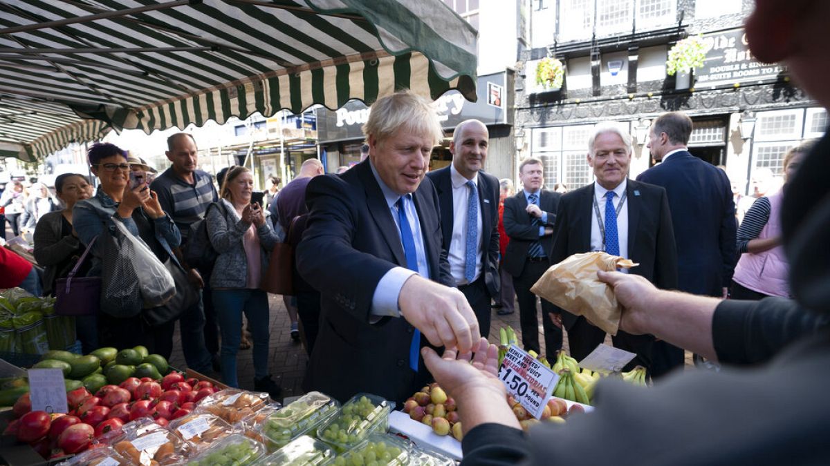 Britain's Prime Minister Boris Johnson shops at a fruit and vegetable stall during a visit to Doncaster Market, in Doncaster, Northern England, Friday Sept. 13, 2019. 
