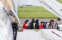 People disembark from an Air Belgium chartered plane, carrying passengers as part of an evacuation from Afghanistan, upon arrival in Belgium, Friday, Aug. 27, 2021.