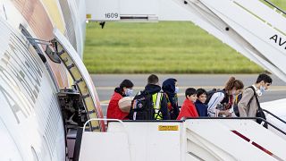 People disembark from an Air Belgium chartered plane, carrying passengers as part of an evacuation from Afghanistan, upon arrival in Belgium, Friday, Aug. 27, 2021.