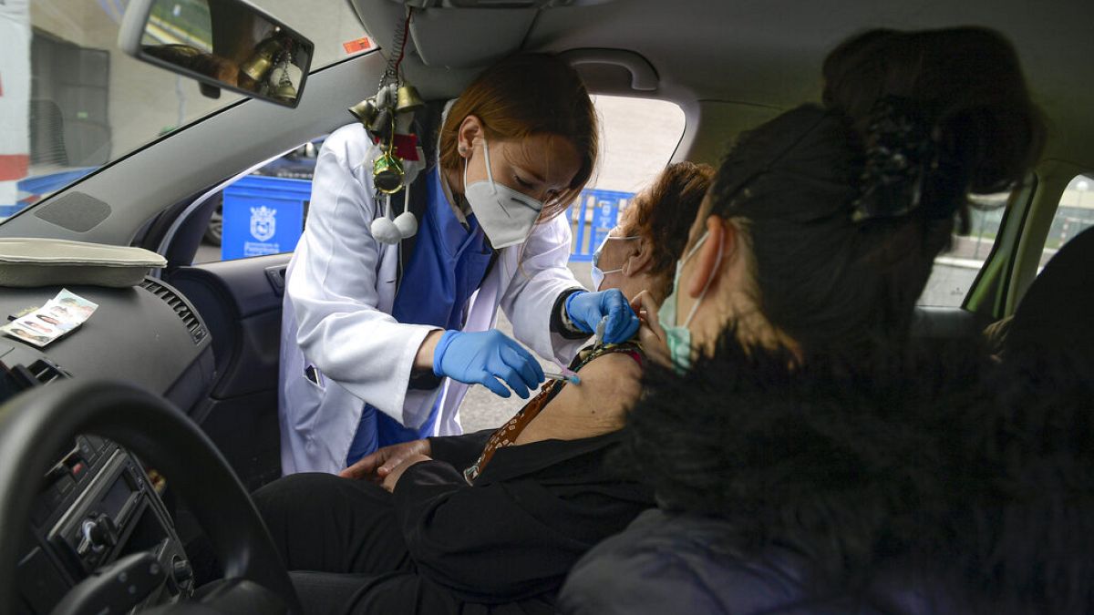Elena Somalo, 88, receives a Pfizer vaccine in her car during a COVID-19 vaccination campaign in Pamplona, northern Spain, Tuesday, March 16, 2021