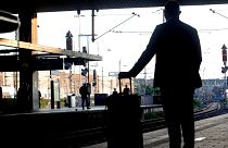 A passenger waits for his train at the main station in Duesseldorf, Germany, Tuesday, Aug. 24, 2021