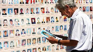 مواطن ألباني يتصفح صور الأشخاص المفقودين في حرب كوسوفو 1998-1999 خارج مبنى حكومي في بريشتينا، السبت 28 أغسطس/آب 2010.