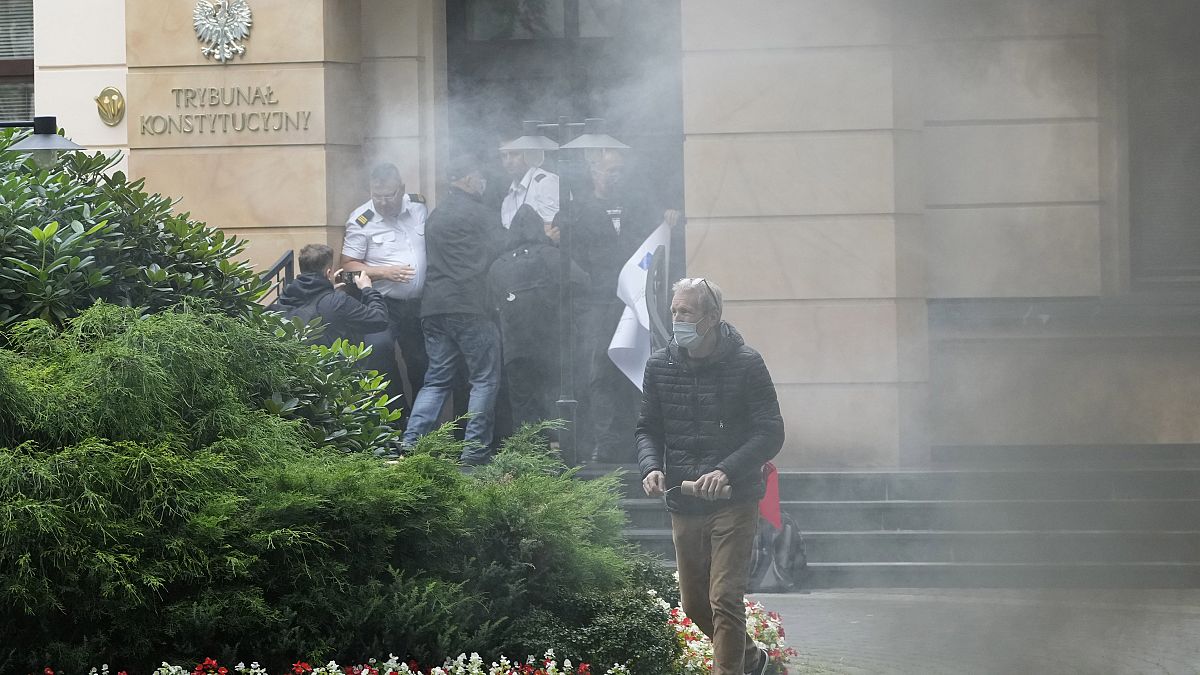 A group of pro-democracy activists in Poland seek to bloc the entrance of the constitutional court in an act of civil disobedience in Warsaw, Poland, on Monday Aug. 30, 2021