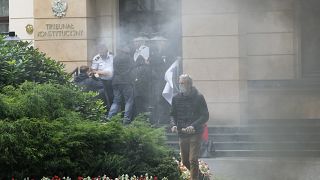 A group of pro-democracy activists in Poland seek to bloc the entrance of the constitutional court in an act of civil disobedience in Warsaw, Poland, on Monday Aug. 30, 2021