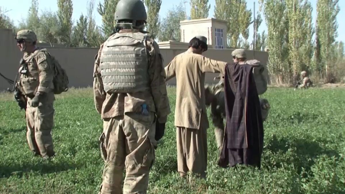 جندي أمريكي يفتش مدنيا أفغانيا