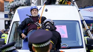 عناصر من الشرطة البريطانية يوقفون متظاهر فوق شاحنة، خلال احتجاج نظمته حركة "إكستنكشن ريبيليين" لحماية البيئة في لندن.
