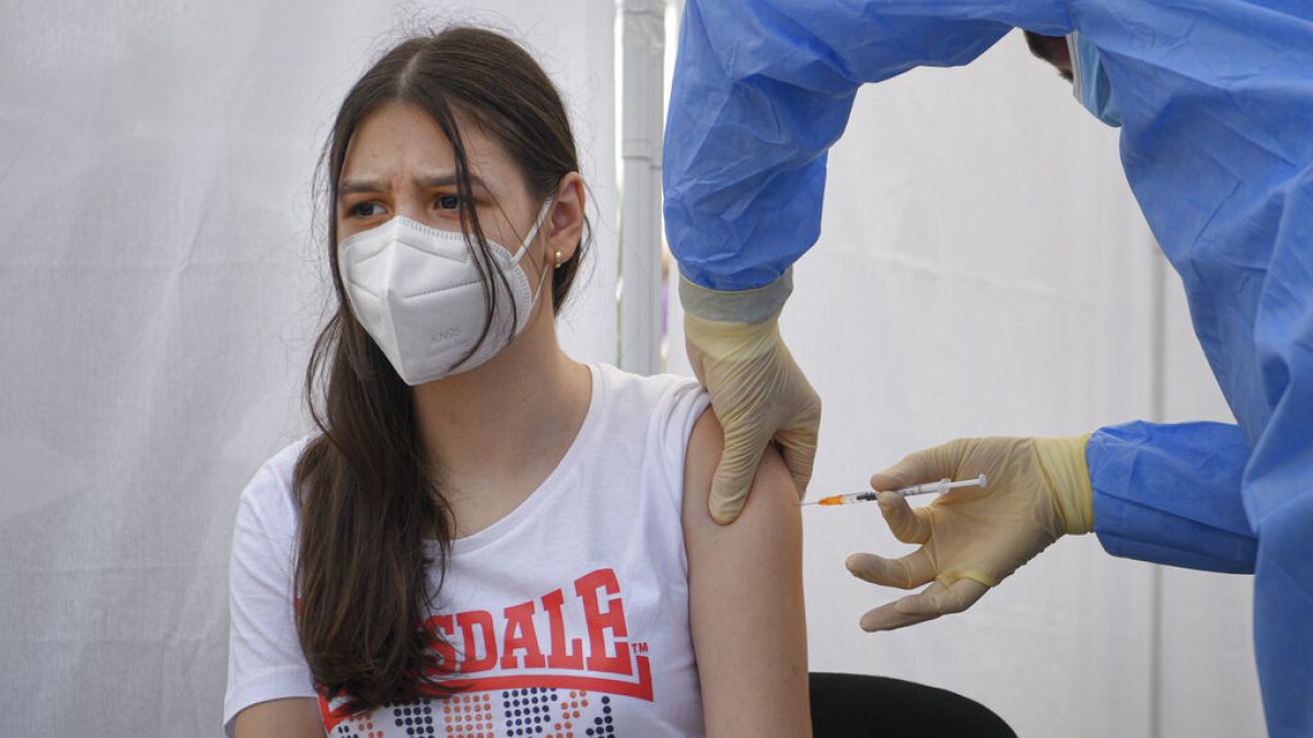 A girl gets a Pfizer BioNTech COVID-19 vaccine in Bucharest