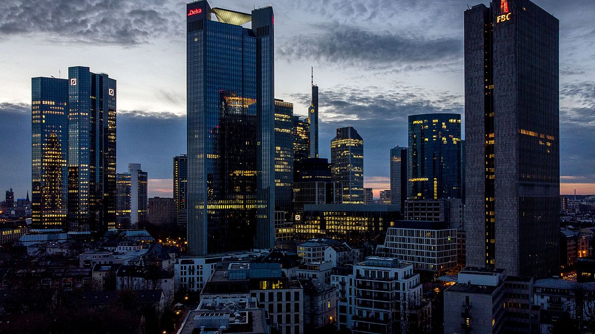 In this Monday, March 29, 2021 file photo, lights burn in some offices of the buildings of the banking district in Frankfurt, Germany. 