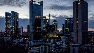 In this Monday, March 29, 2021 file photo, lights burn in some offices of the buildings of the banking district in Frankfurt, Germany. 