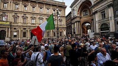 People stage a protest against the COVID-19 vaccination pass in Milan, Italy, Wednesday, July 28, 2021. People stage a protest against the COVID-19 vaccination pass in Milan, Italy, Wednesday, July 28, 2021.
