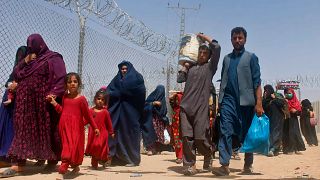 Afghans entering Pakistan through a common border crossing point in Chaman