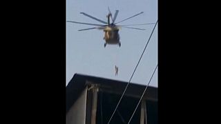 رجل يتدلى من حبل مربوط بطائرة مروحية عسكرية تحلق فوق قندهار.