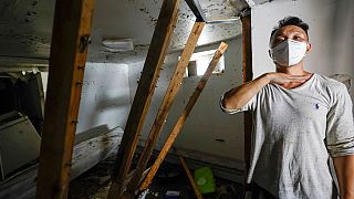 Danny Hong shows where the water reached up to him as he shows the damage in his basement apartment on 153rd St. in the Flushing neighborhood of the Queens borough of New York