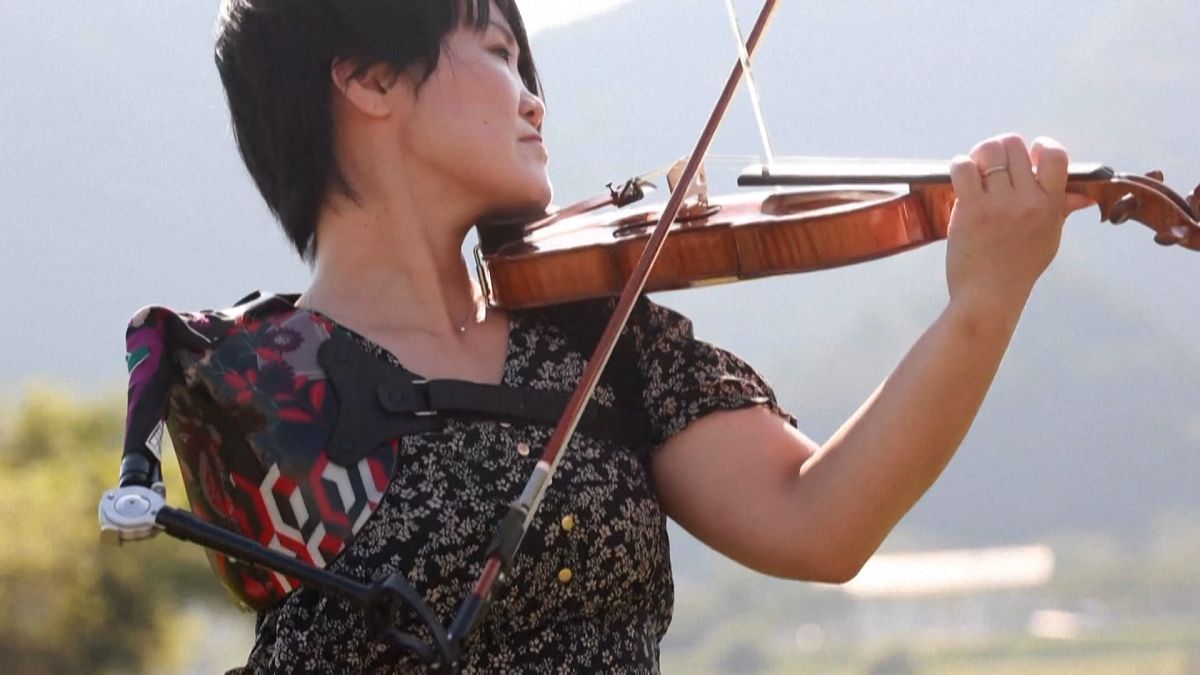 Ito playing violin with her special prosthetic arm