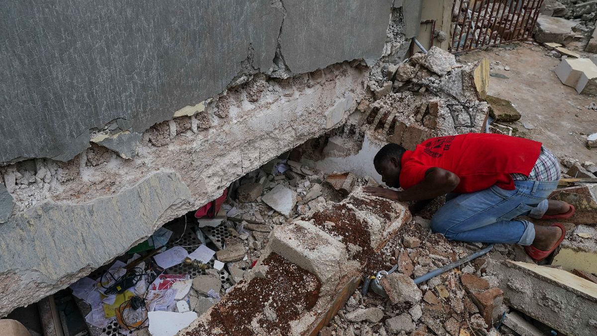 Um homem olha pelo buraco aberto numa escola afetada pelo sismo