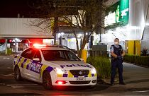 Police stand outside the site of a knife attack at a supermarket in Auckland.