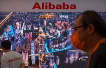 Çin'in başkenti Pekin'de bir teknoloji fuarında Alibaba standının önünden geçen bir kişi
