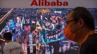 Çin'in başkenti Pekin'de bir teknoloji fuarında Alibaba standının önünden geçen bir kişi 