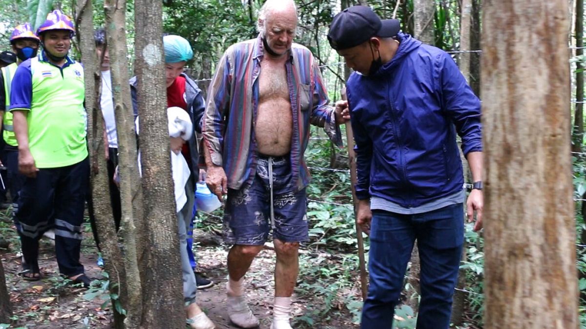Rescuers lead Barry Leonard Weller, 72, out of the jungle, in Thailand's northeastern Khon Kaen province, Friday, Sept. 3, 2021.