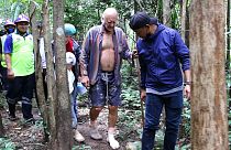 Rescuers lead Barry Leonard Weller, 72, out of the jungle, in Thailand's northeastern Khon Kaen province, Friday, Sept. 3, 2021.