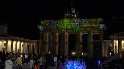Brandenburg Gate with crowds of people at opening of Festival of Lights event.