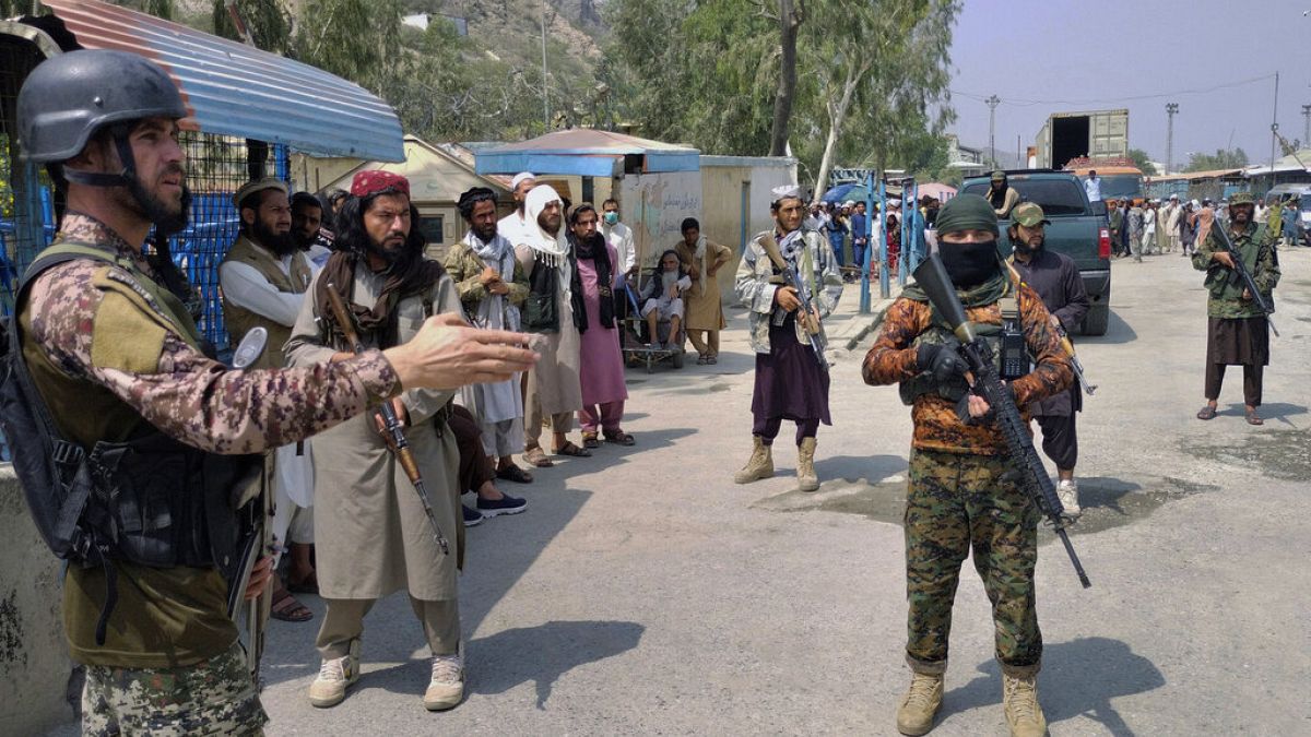 Ein pakistanischer paramilitärischer Soldat (links) und Taliban-Kämpfer am 5. September 2021 an einem Grenzübergang zwischen Pakistan und Afghanistan.