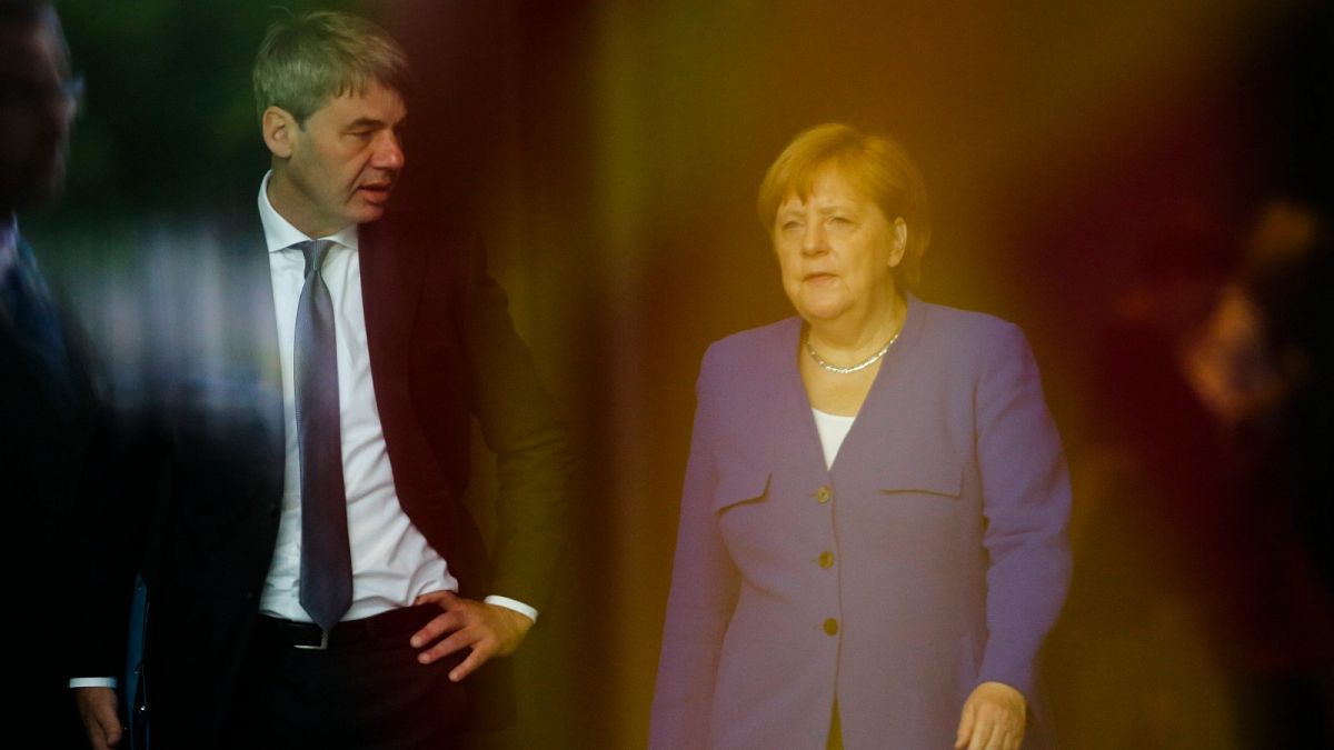 In this June 13, 2019, file photo, German Chancellor Angela Merkel, right, talks to then foreign policy advisor Jan Hecker, left.