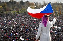 A woman waves a Czech flag from a roof as people take part in a large anti-government protest in Prague, Czech Republic, Saturday, Nov. 16, 2019 A woman waves a Czech flag from a roof as people take part in a large anti-government protest in Prague, Czech Republic, Saturday, Nov. 16, 2019