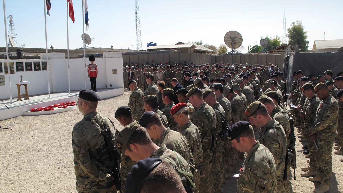 جنود بريطانيون بقيادة حلف شمال الأطلسي يقفون دقيقة صمت خلال احتفال يوم المحاربين البريطانيين القدامى في قاعدة الناتو في لشكركاه، جنوب كابول، أفغانستان، الأحد 11 نوفمبر 2012