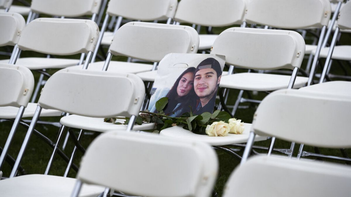 Φωτογραφία δύο από τα θύματα της πτήσης MH17, στις 298 άδειες καρέκλες που τοποθετήθηκαν έξω τη ρωσική πρεσβεία στη Χάγη
