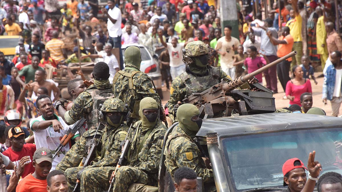 احتفال الناس في الشوارع مع أفراد القوات المسلحة الغينية بعد القبض على رئيس غينيا، ألفا كوندي، في انقلاب في كوناكري، 5 سبتمبر 2021.