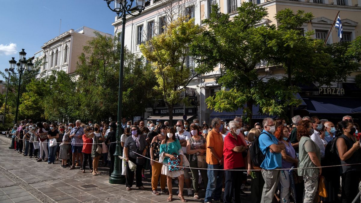 People wait outside the Athens Cathedral to pay respects to the late Greek composer Mikis Theodorakis in Athens on Monday Sept. 6, 2021.