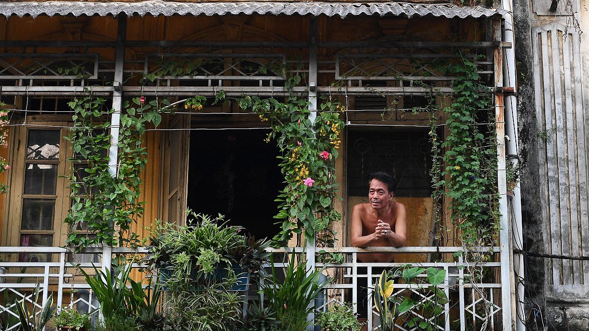 رجل ينظر من شرفة منزله في هانوي، أثناء الإغلاق  الصارم الذي فرضته الحكومة