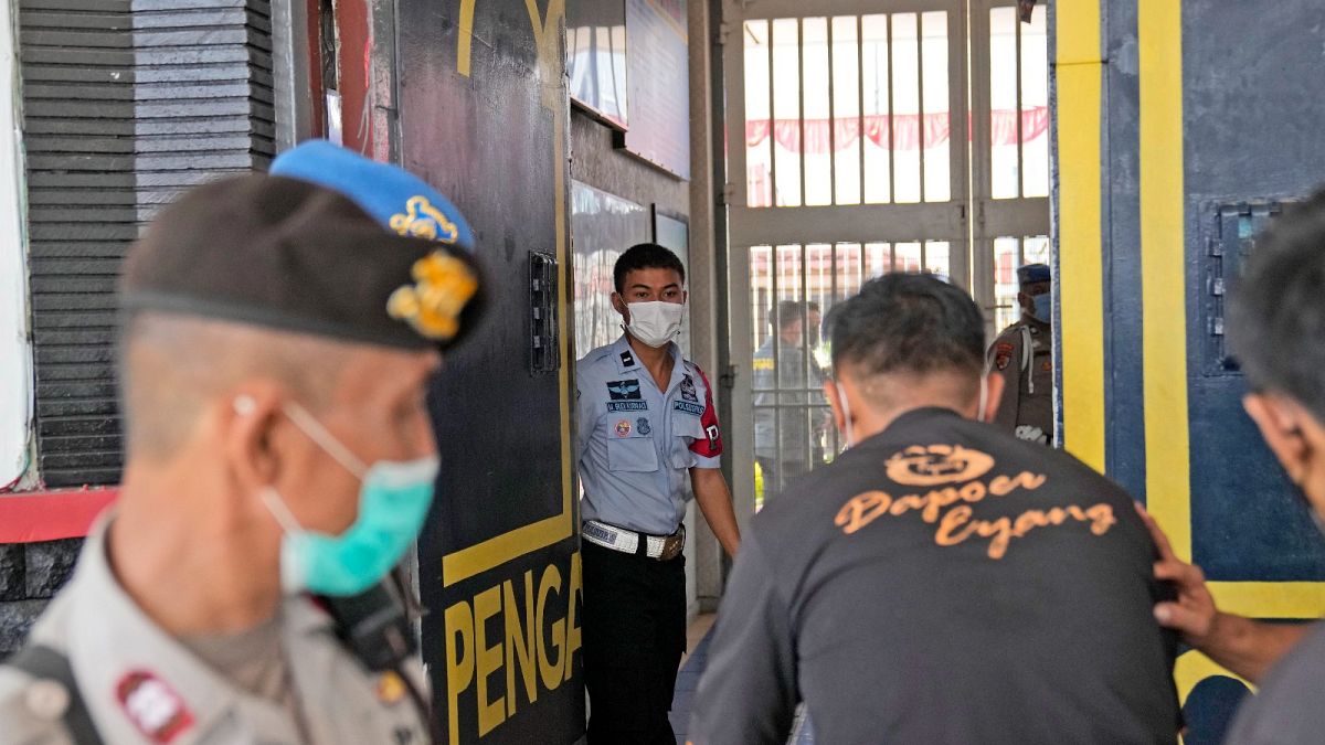 Staff and police officers guard the main entrance gate of Tangerang prison in Tangerang on the outskirts of Jakarta, Indonesia, Wednesday, Sept. 8, 2021.
