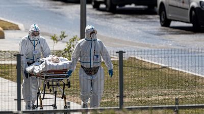 medical workers carry a patient suspected of having coronavirus at a hospital in Kommunarka, outside Moscow, Russia, June 26, 2021. medical workers carry a patient suspected of having coronavirus at a hospital in Kommunarka, outside Moscow, Russia, June 26, 2021.
