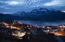 Homes are illuminated after the sunset in Tasiilaq, Greenland.