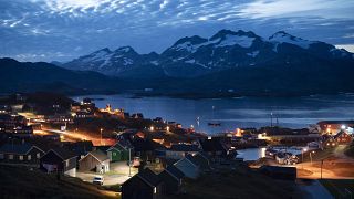 Homes are illuminated after the sunset in Tasiilaq, Greenland.