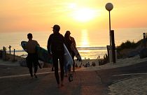 The sun sets over surfers in Hossegor, France.