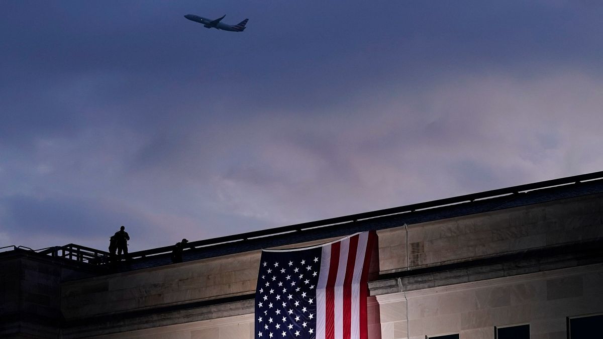 Foto de archivo: un avión despega del Aeropuerto Nacional Reagan de Washington mientras se despliega una gran bandera estadounidense en el Pentágono. 