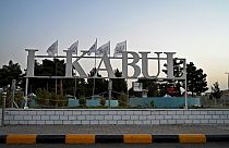 The Taliban flags are pictured behind a sign installed outside the airport in Kabul on September 9, 2021.