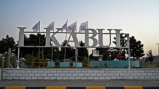 The Taliban flags are pictured behind a sign installed outside the airport in Kabul on September 9, 2021.