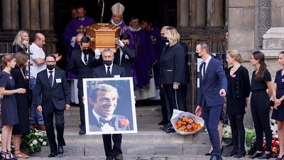 Pallbearers carry a portrait and the coffin of Jean-Paul Belmondo after the funeral ceremony for the late French actor.