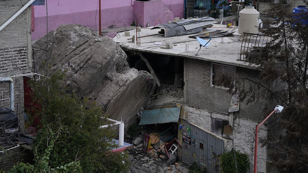 A boulder that plunged from a mountainside rests among homes in Tlalnepantla, on the outskirts of Mexico City.