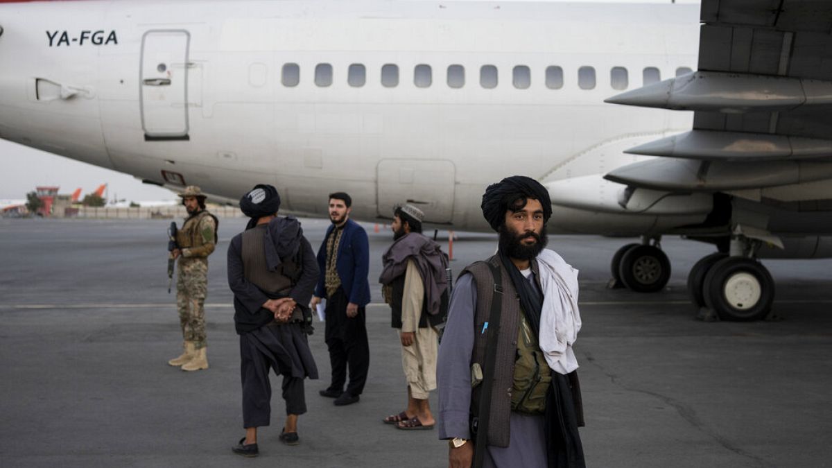Tálibok állnak egy repülőgép mellett szeptember 9-én csütörtökön a kabuli repülőtéren, amikor több száz amerikainak sikerült elhagynia Afganisztánt 