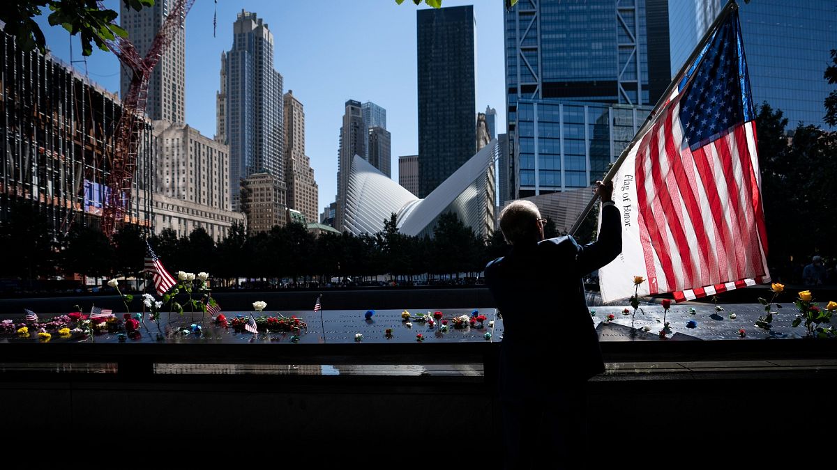 Az Egyesült Államok lobogóját tartja Germano Rivera a New York-i Ground Zero emlékműnél 2021. szeptember 11-én
