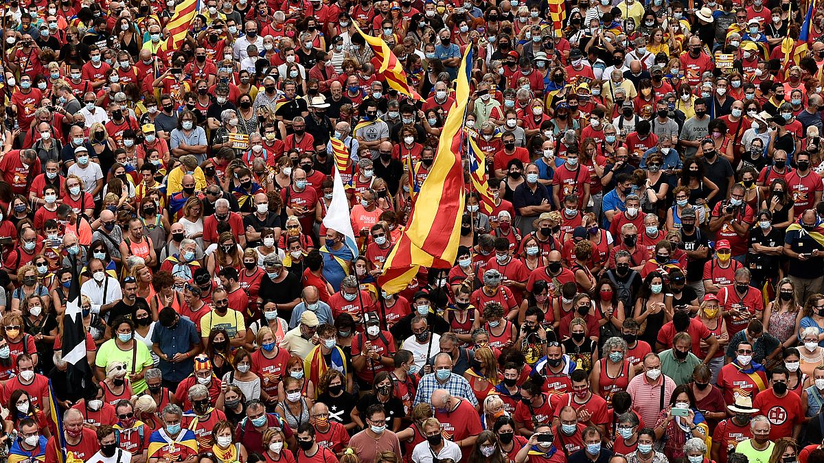 People wave Catalan pro-independence "Estelada" flags during a demonstration marking the "Diada", national day of Catalonia, in Barcelona on September 11, 2021.