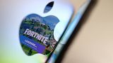 This file illustration photo shows the opening screen of Epic Games’ Fortnite reflecting onto the Apple logo of the back of an I-mac in Los Angeles on May 3, 2021.