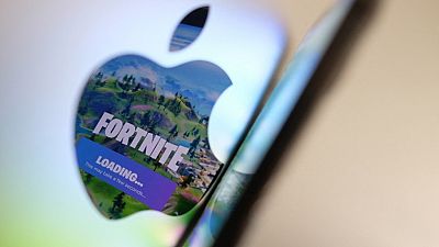 This file illustration photo shows the opening screen of Epic Games’ Fortnite reflecting onto the Apple logo of the back of an I-mac in Los Angeles on May 3, 2021.