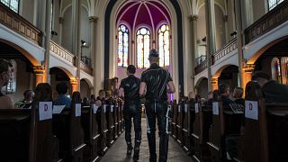 Guests, fully clothed in leather, take their seats at the "Classic meets Fetish" concert at the Twelve Apostles Church in Berlin.
