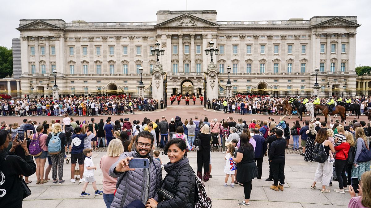 Members of the public watch the Changing of the Guard ceremony at Buckingham Palace, London, Monday August 23, 2021